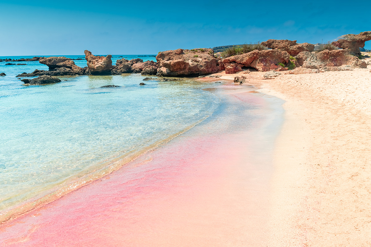En sandstrand med toner i rosa. 
