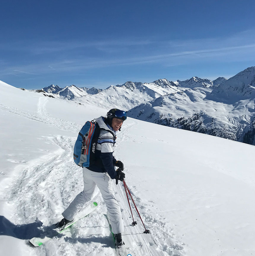 Kvinne i hvit skidress i skibakke. 