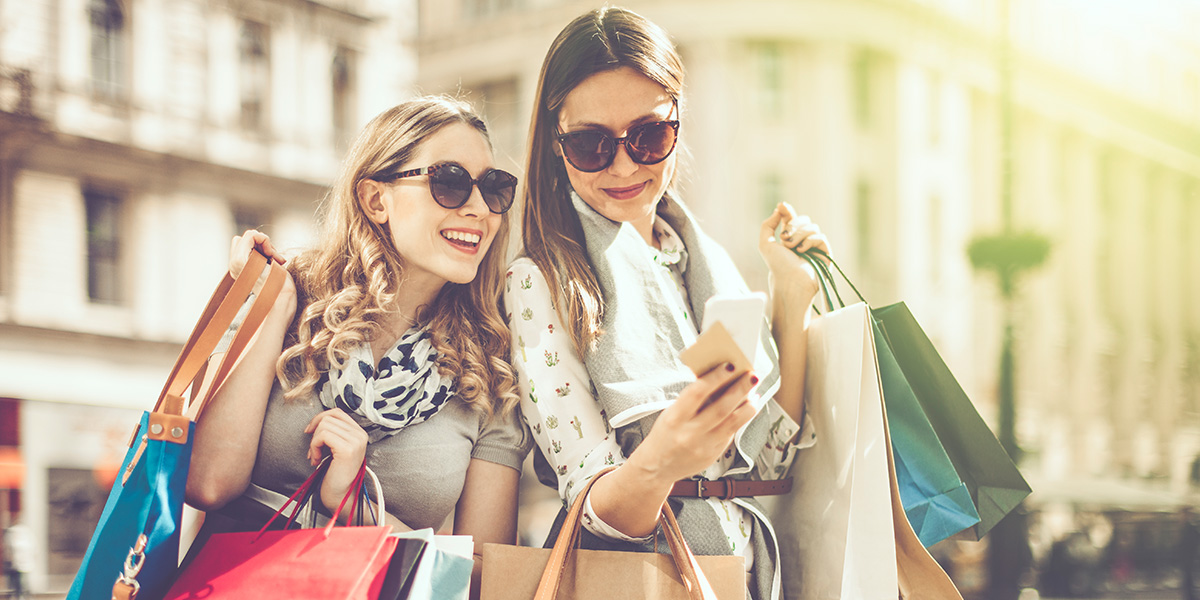 To jenter med solbriller og shoppingposer i Paris