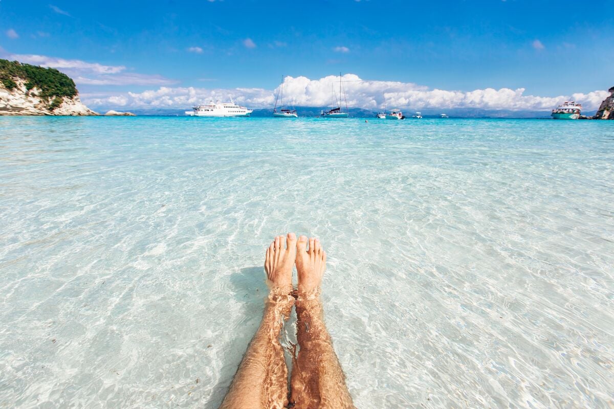 Kvinneben i vannkanten på en strand