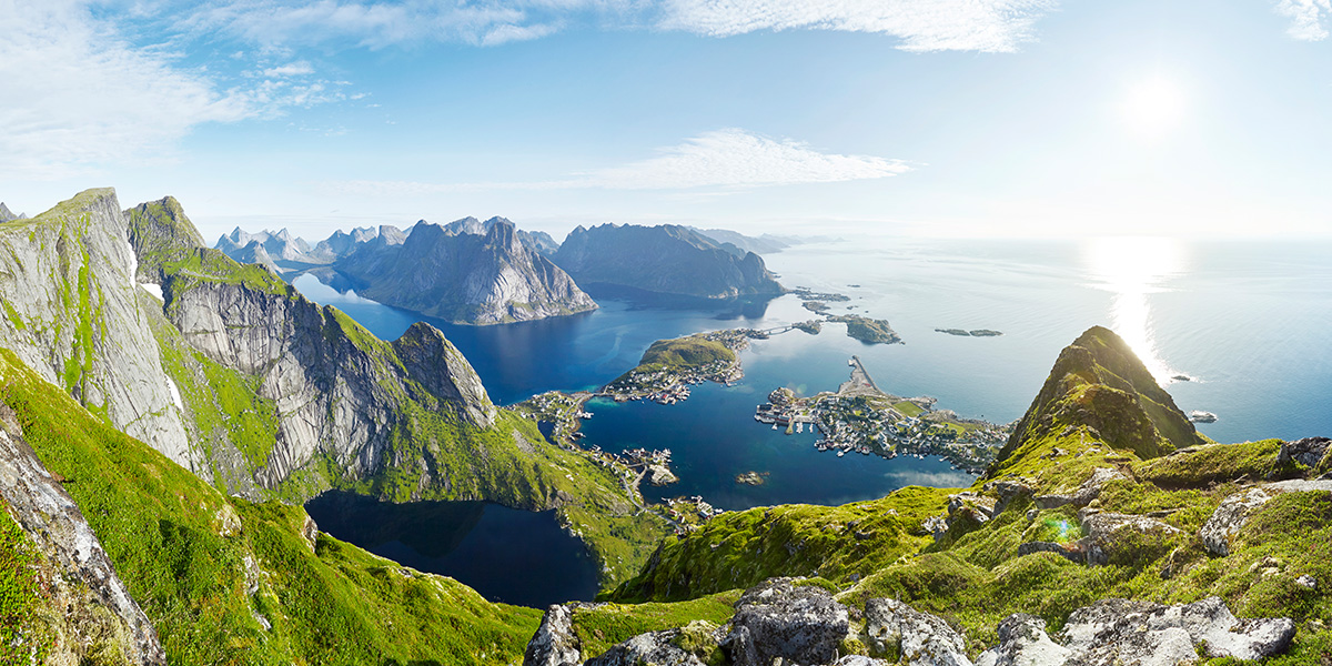 Overview of mountains covered in greenery high above the ocean and islands