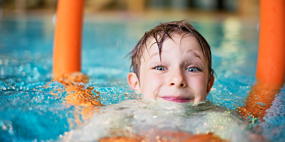 Lille dreng i en swimmingpool på et flydende element
