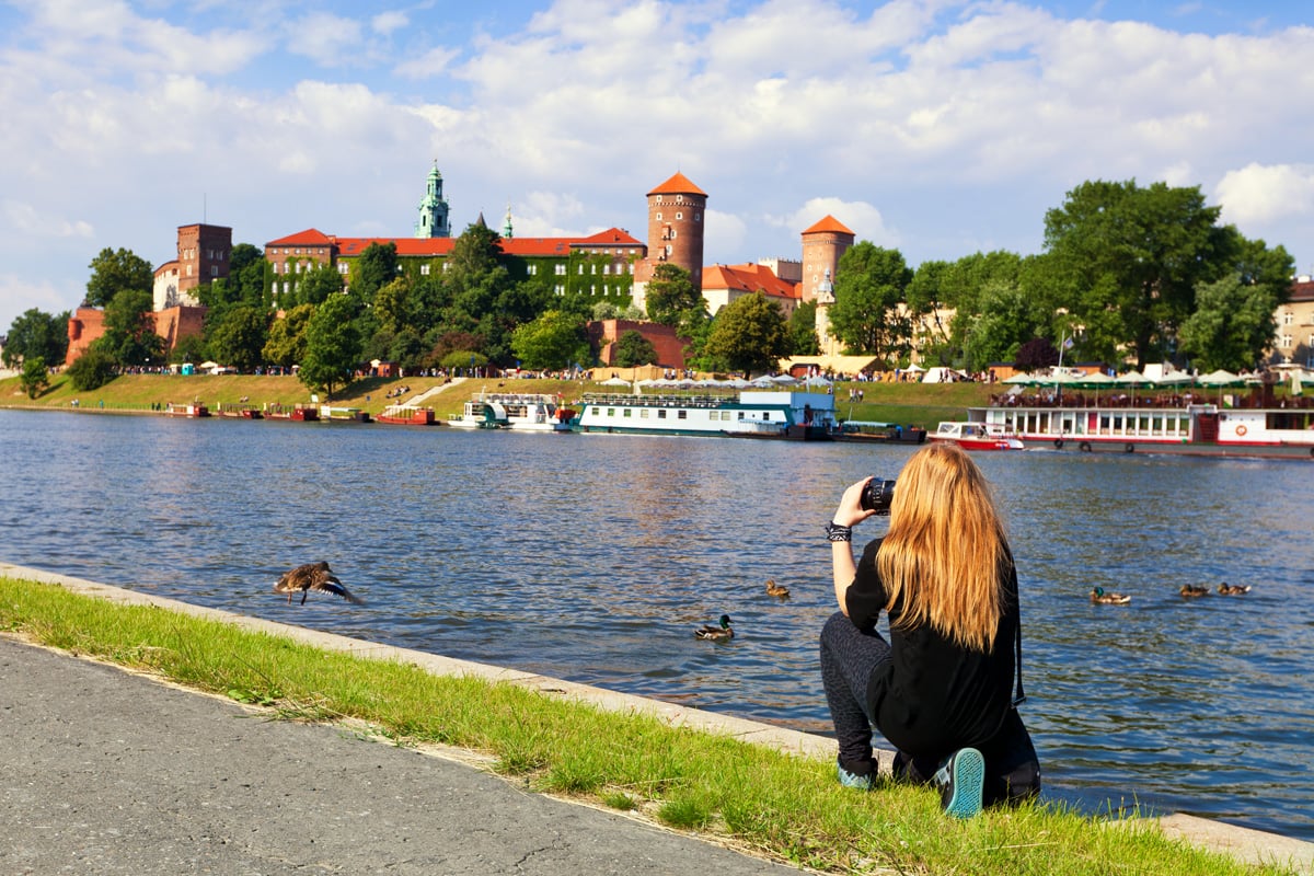 Kvinna tar bilder vid vattnet vid en fästning