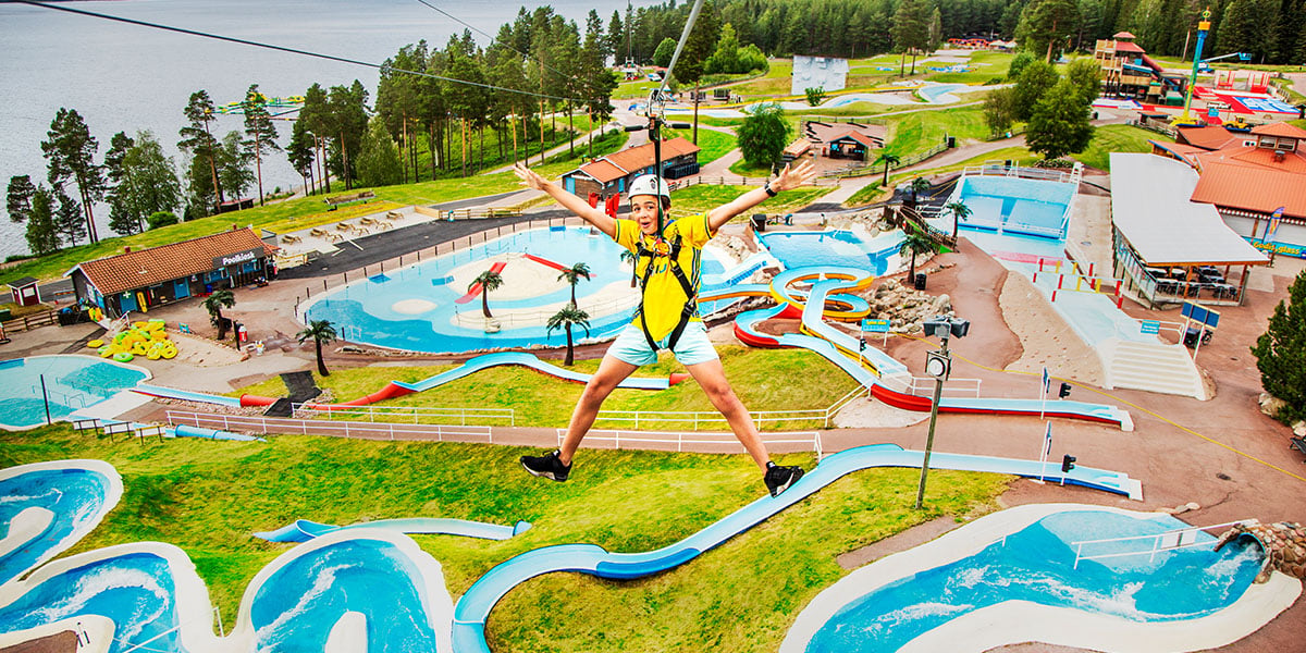 En person tar en Zip-line over et badeland utendørs