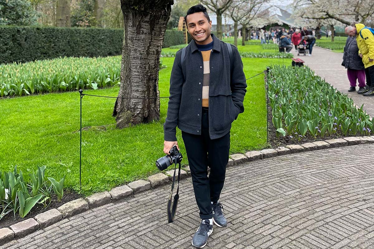 A young man in a park posing for camera
