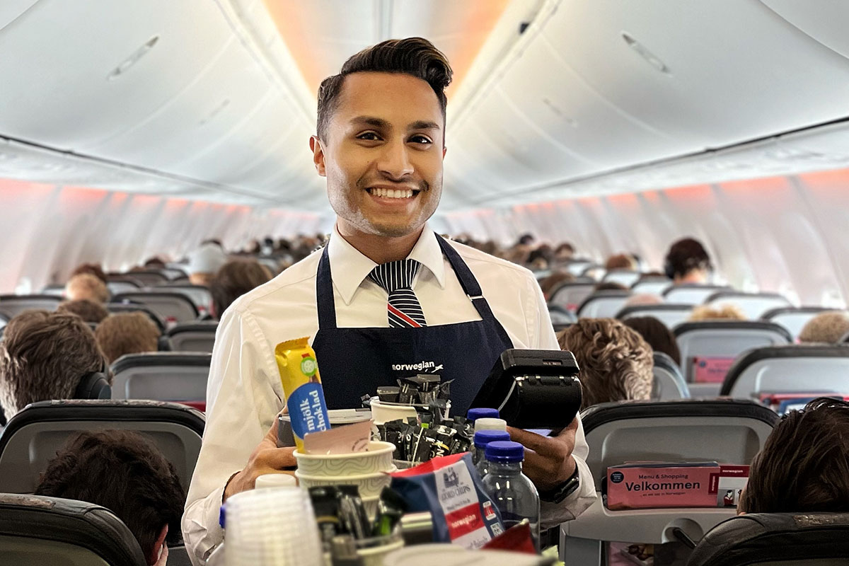 Cabin crew inside a plane with a trolley