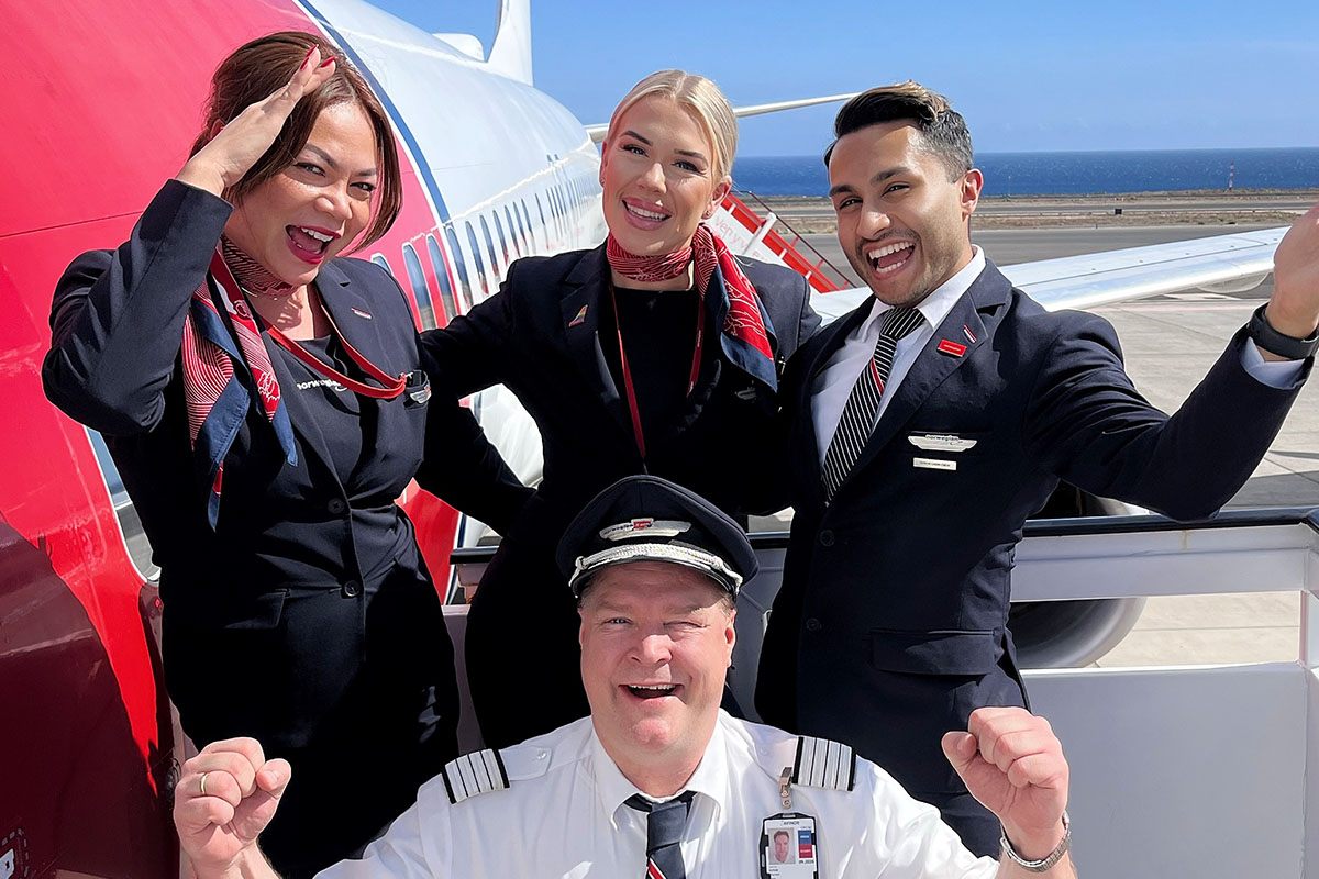 Crew posing outside of a plane