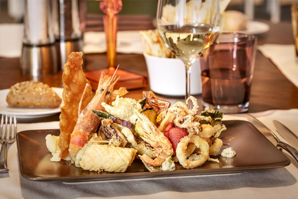 Fly to Olbia in Sardinia, dine at Bacchus.
